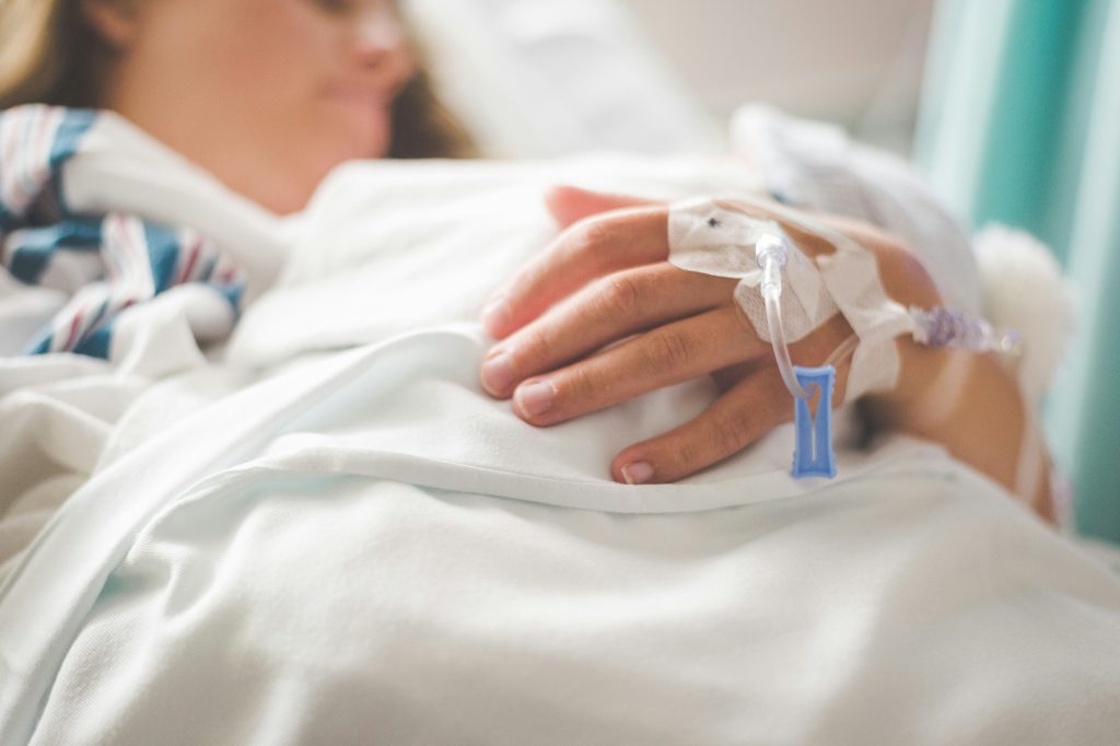 close up of a caucasian's person hand at a hospital with an IV taped in