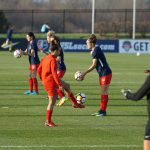 womens soccer team warming up on grass