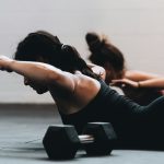 woman on her stomach doing strength training in a group setting